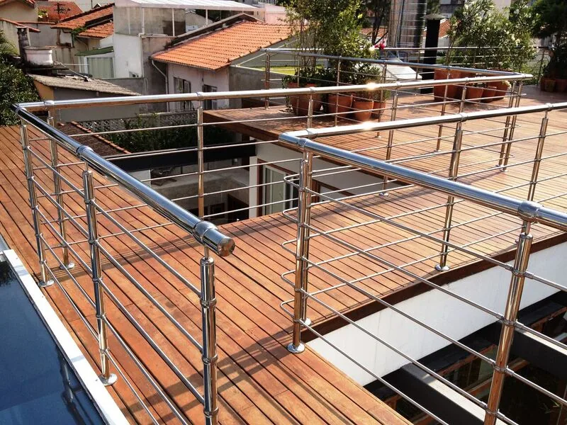 Stainless steel horizontal rod railing with round handrail on a hardwood rooftop deck